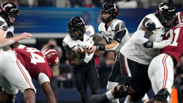 Cincinnati Bearcats quarterback Desmond Ridder (9) hands the ball off to Cincinnati Bearcats running back Jerome Ford (24) in the first quarter during the College Football Playoff semifinal game at the 86th Cotton Bowl Classic, Friday, Dec. 31, 2021, at AT&T Stadium in Arlington, Texas.