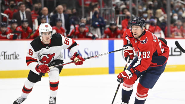 Jan 2, 2022; Washington, District of Columbia, USA; Washington Capitals center Evgeny Kuznetsov (92) advances the puck as New Jersey Devils center Jack Hughes (86) looks on during the third period at Capital One Arena. Mandatory Credit: Brad Mills-USA TODAY Sports