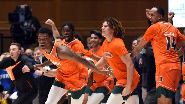 The Miami Hurricanes bench storms the court after defeating the Duke Blue Devils at Cameron Indoor Stadium.
