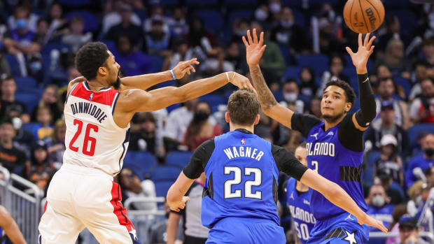 Jan 9, 2022; Orlando, Florida, USA; Washington Wizards guard Spencer Dinwiddie (26) passes the ball in front of Orlando Magic forward Franz Wagner (22) and forward Chuma Okeke (3) during the second half at Amway Center. Mandatory Credit: Mike Watters-USA TODAY Sports