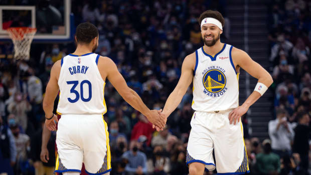 Jan 9, 2022; San Francisco, California, USA; Golden State Warriors guard Klay Thompson (11) gets a congratulatory handshake from teammate Stephen Curry (30) after making a basket against the Cleveland Cavaliers during the first quarter at Chase Center. Mandatory Credit: D. Ross Cameron-USA