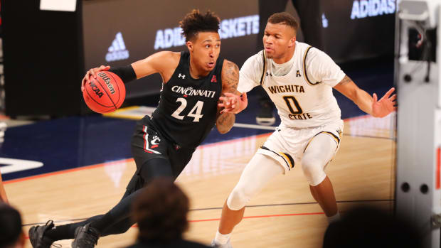 Mar 13, 2021; Fort Worth, TX, USA; Cincinnati Bearcats guard Jeremiah Davenport (24) drives to the basket against Wichita State Shockers guard Dexter Dennis (0) during the second half at Dickies Arena. Mandatory Credit: Ben Ludeman-USA TODAY Sports