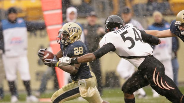 Dec 5, 2009; Pittsburgh, PA, USA; Pittsburgh Panthers running back Dion Lewis (28) runs for a touchdown past the Cincinnati Bearcats line man Walter Stewart (54). The Bearcats defeated the Panthers 45-44 at Heinz Field. Mandatory Credit: Brett Hansbauer-USA TODAY Sports