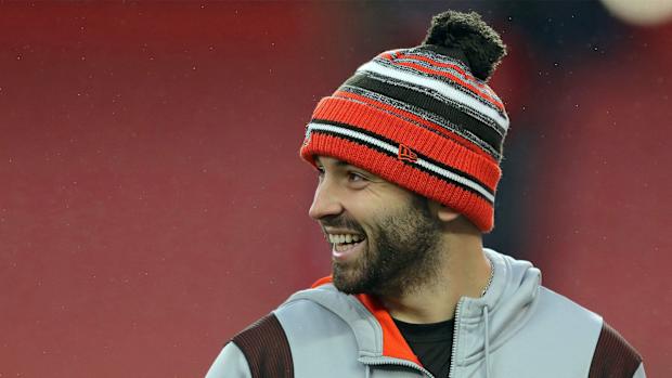 Browns quarterback Baker Mayfield laughs as he watches his teammates warm up before a game against the Cincinnati Bengals, Sunday, Jan. 9, 2022, in Cleveland.