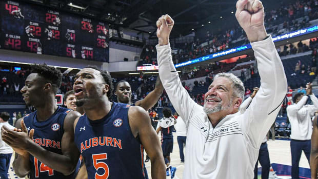 Auburn guard Preston Cook (14), forward Chris Moore (5), and head coach Bruce Pearl celebrate a win over Mississippi in an NCAA college basketball game in Oxford, Miss., Saturday, Jan. 15, 2022.