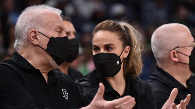 Dec 31, 2021; Memphis, Tennessee, USA; San Antonio Spurs head coach Gregg Popovich (left) and assistant coach Becky Hammon (center) talk during the first half against the Memphis Grizzlies at FedExForum.