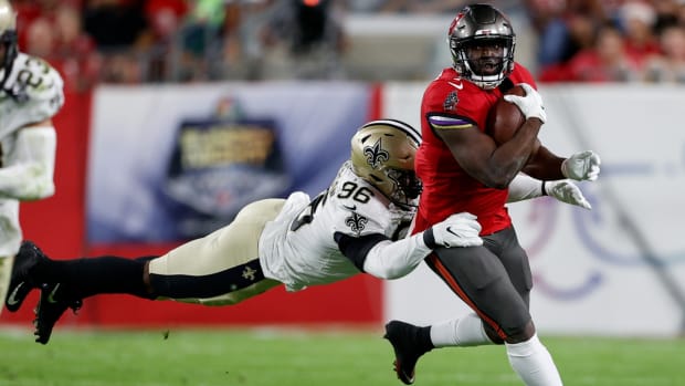 Dec 19, 2021; Tampa, Florida, USA; Tampa Bay Buccaneers running back Leonard Fournette (7) is tackled by New Orleans Saints defensive end Carl Granderson (96) in the first quarter at Raymond James Stadium. Mandatory Credit: Nathan Ray Seebeck-USA TODAY Sports