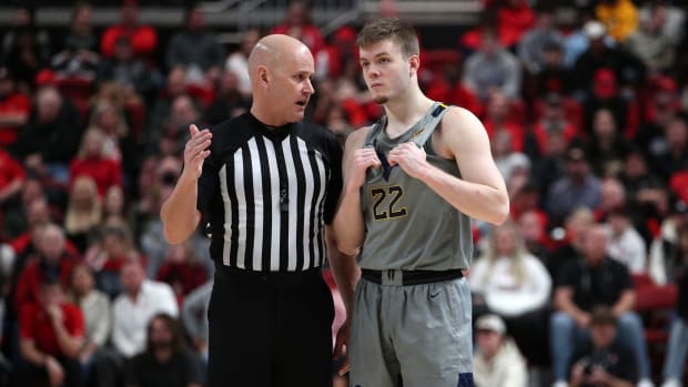Jan 22, 2022; Lubbock, Texas, USA; West Virginia Mountaineers guard Sean McNeil (22) visits with Big 12 official Kipp Kissinger in the second half during the game against the Texas Tech Red Raiders at United Supermarkets Arena.