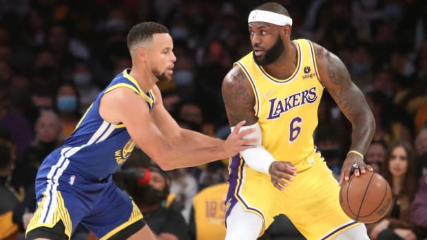 Los Angeles Lakers forward LeBron James (6) dribbles a ball against Golden State Warriors guard Stephen Curry.