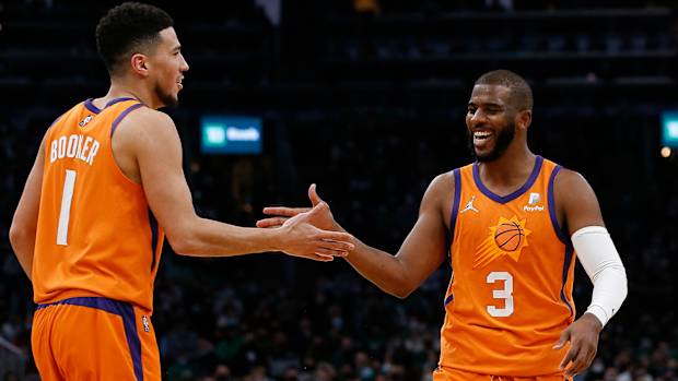 Phoenix Suns guards Devin Booker Chris Paul celebrate after a basket against the Boston Celtics.