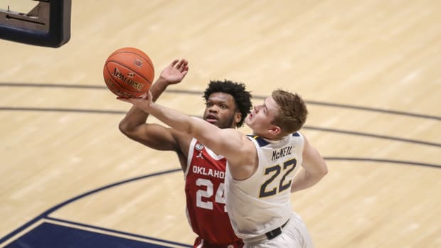Feb 13, 2021; Morgantown, West Virginia, USA; West Virginia Mountaineers guard Sean McNeil (22) drives and shoots against Oklahoma Sooners guard Elijah Harkless (24) during overtime at WVU Coliseum.