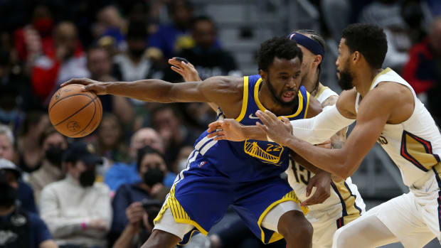 Jan 6, 2022; New Orleans, Louisiana, USA; Golden State Warriors forward Andrew Wiggins (22) dribbles the ball while defended by New Orleans Pelicans forward Garrett Temple (41) and guard Jose Alvarado (15) in the second half at the Smoothie King Center. Mandatory Credit: Chuck Cook-USA TODAY Sports