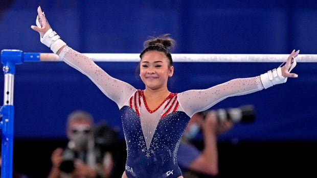 Suni Lee salutes after completing her uneven bars routine at the 2020 Olympics.