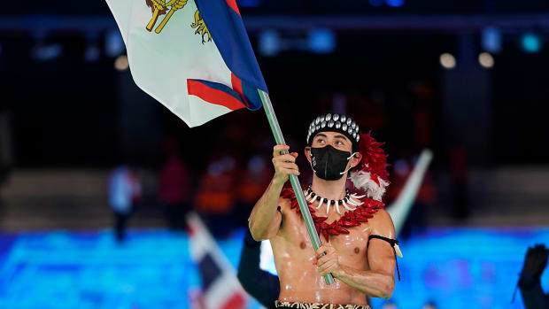 Nathan Crumpton, of American Samoa, carries his national flag into the stadium during the opening ceremony of the 2022 Winter Olympics, Friday, Feb. 4, 2022, in Beijing.