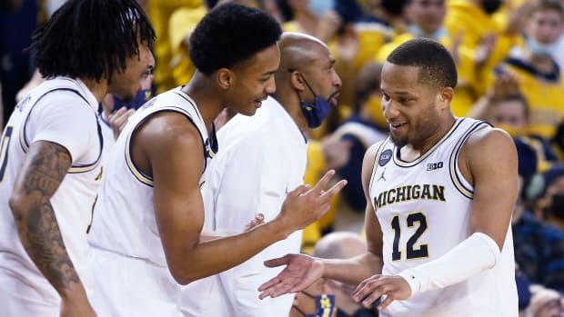 Michigan's DeVante' Jones celebrates with teammates