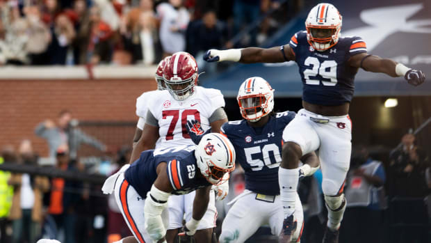 Auburn Tigers defensive end Colby Wooden (25), defensive lineman Marcus Harris (50) and defensive lineman Derick Hall (29) celebrate a sack against Alabama quarterback Bryce Young (9) during the Iron Bowl at Jordan-Hare Stadium in Auburn, Ala., on Saturday, Nov. 27, 2021. Ncaa Football Alabamaat Auburn