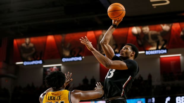 Cincinnati Bearcats forward Ody Oguama (33) puts up a shot over Wichita State Shockers forward Morris Udeze (24) in the second half of the NCAA American Athletic Conference basketball game between the Cincinnati Bearcats and the Wichita State Shockers at Fifth Third Arena in Cincinnati on Thursday, Feb. 17, 2022. The Bearcats carried a halftime lead to win 85-76 in the conference matchup. Wichita State Shockers At Cincinnati Bearcats Basketball