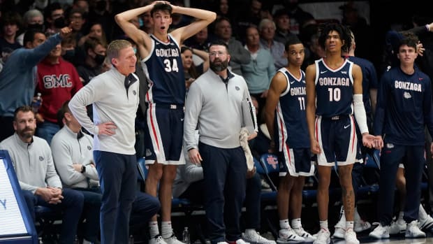 Alt text: Gonzaga coach Mark Few, standing at left, reacts to a call with Chet Holmgren (34), Nolan Hickman (11) and Hunter Sallis (10) during the second half of the team's NCAA college basketball game against Saint Mary's in Moraga, Calif., Saturday, Feb. 26, 2022.