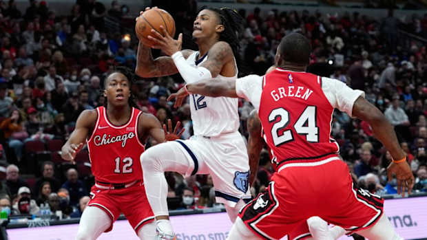 Memphis Grizzlies' Ja Morant, center, drives to the basket between Chicago Bulls' Ayo Dosunmu, left, and Javonte Green, right, during the second half of an NBA basketball game Saturday, Feb. 26, 2022, in Chicago.
