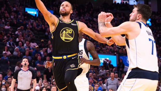 Feb 27, 2022; San Francisco, California, USA; Golden State Warriors guard Stephen Curry (30) goes up for a shot against Dallas Mavericks guard Luka Doncic (77) during the fourth quarter at Chase Center. Mandatory Credit: Kelley L Cox-USA TODAY Sports