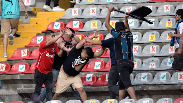 Supporters of Atlas fight with supporters of Queretaro during the Mexican Clausura tournament football match between Queretaro and Atlas at Corregidora stadium in Queretaro, Mexico on March 5, 2022. - A match between Mexican football clubs was called off March 5, 2022 after violence by opposing fans spilled onto the field. The game between Queretaro and Atlas at La Corregidora stadium in the city of Queretaro -- the ninth round of the 2022 Clausura football tournament -- was in its 63rd minute when fights between opposing fans broke out.