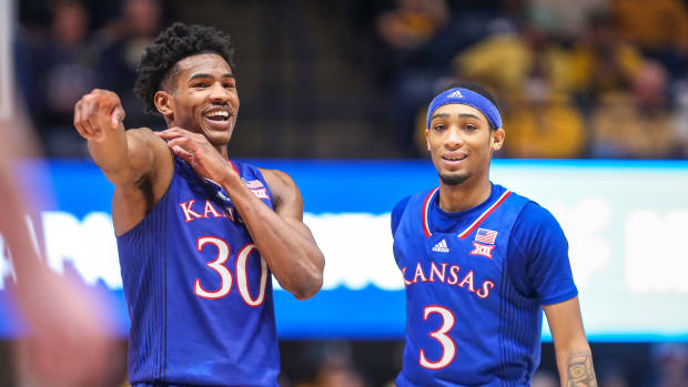 Kansas’s Ochai Agbaji (30) talks with guard Dajuan Harris Jr.