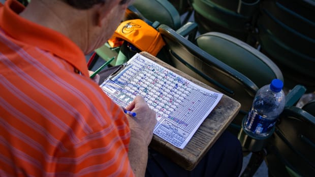 An MLB fan fills out a scorecard