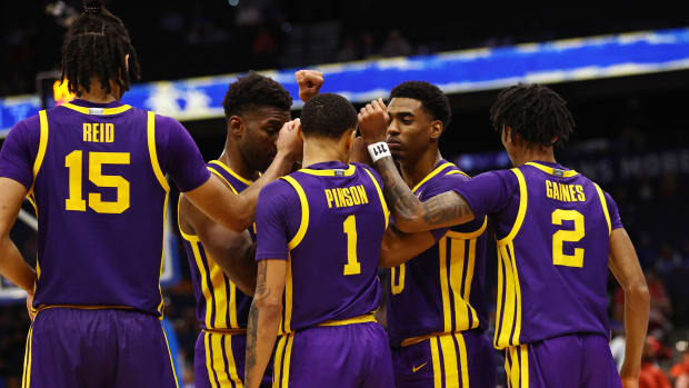 LSU men’s basketball players huddle together during a game.