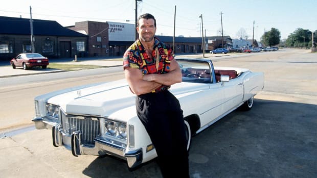 Scott Hall poses in front of a Cadillac