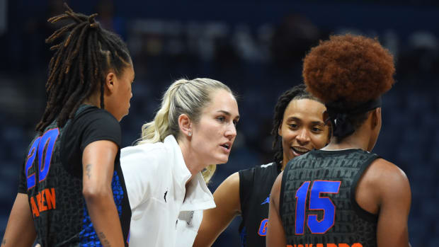 Coach Kelly Rae Finley talks with three Florida basketball players