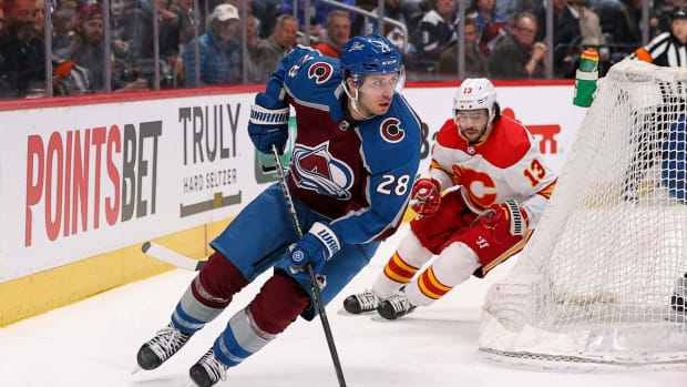 Mar 13, 2022; Denver, Colorado, USA; Colorado Avalanche defenseman Ryan Murray (28) controls the puck ahead of Calgary Flames left wing Johnny Gaudreau (13) in the first period at Ball Arena. Mandatory Credit: Isaiah J. Downing-USA TODAY Sports