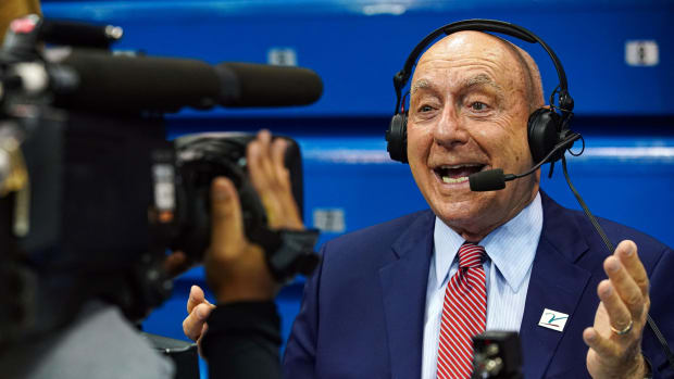 Dick Vitale talks in the direction of a camera before a game.