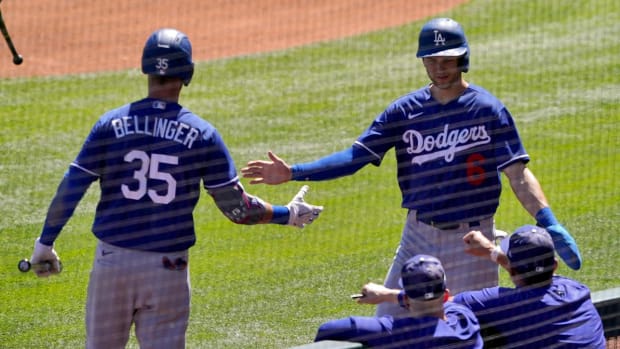 Los Angeles Dodgers’ Trea Turner greets Cody Bellinger (35) after scoring on a base hit by Freddie Freeman during the first inning of a spring training baseball game against the Colorado Rockies, Thursday, March 24, 2022, in Scottsdale, Ariz.