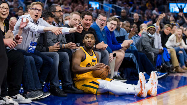 Utah Jazz guard Donovan Mitchell falls onto coursed fans during the second half against the Golden State Warriors.