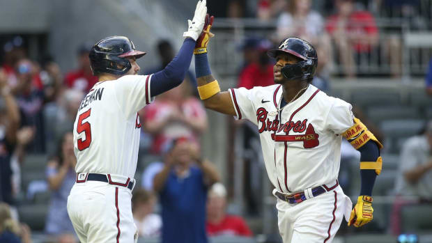 Ronald Acuña Jr. and Freddie Freeman high five during a game.