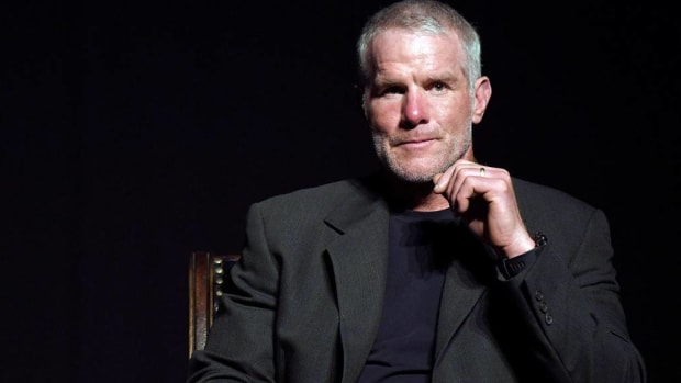 Brett Favre sits in front a black background.