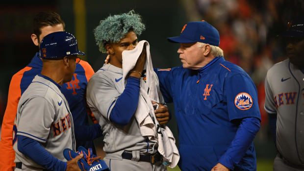 Apr 8, 2022; Washington, District of Columbia, USA; New York Mets shortstop Francisco Lindor (12) covers his face after being hit by pitch while manager Buck Showalter (11) walks with him during the fifth inning against the Washington Nationals at Nationals Park.