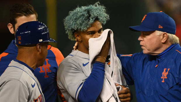 New York Mets shortstop Francisco Lindor (12) covers his face after being hit by pitch