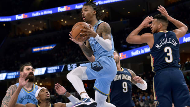 Memphis Grizzlies guard Ja Morant (12) handles the ball between New Orleans Pelicans guard Devonte’ Graham, left, center Willy Hernangomez (9) and guard CJ McCollum (3) during the second half of an NBA basketball game Saturday, April 9, 2022, in Memphis, Tenn.