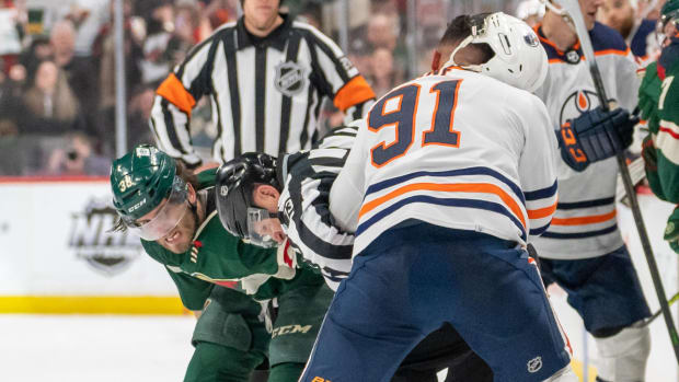 Minnesota Wild right wing Ryan Hartman (38) and Edmonton Oilers left wing Evander Kane (91) fight in front of the benches