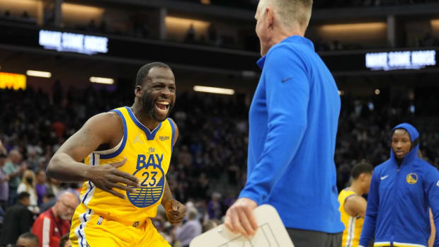 Four-time NBA All-Star Draymond Green slaps hands with Golden State Warriors head coach Steve Kerr.