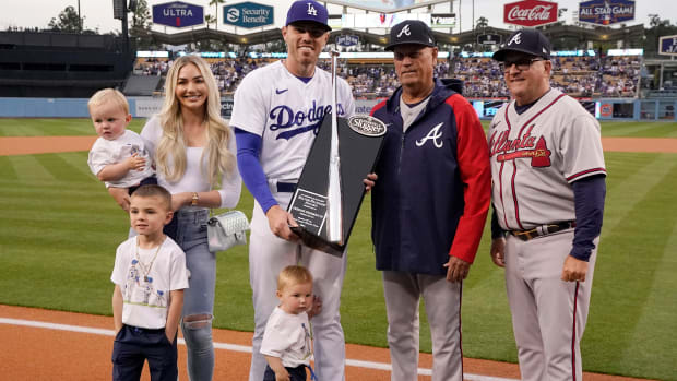 Los Angeles Dodgers’ Freddie Freeman, center, poses with former teammates Atlanta Braves manager Brian Snitker, second from right, and hitting coach Kevin Seitzer along with members of his family after receiving the Silver Slugger award prior to a baseball game Monday, April 18, 2022, in Los Angeles.