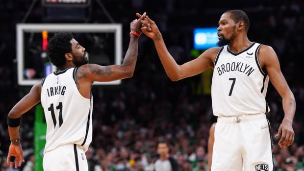 Brooklyn Nets guard Kyrie Irving (11) and forward Kevin Durant (7) react after a play against the Boston Celtics