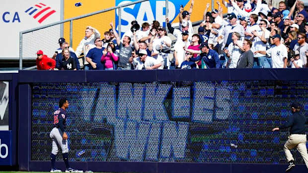 Yankees fans throw trash on the field after beating the Guardians.