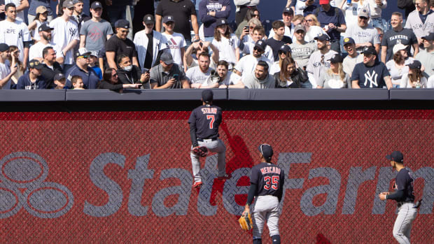 Apr 23, 2022; Bronx, New York, USA; Cleveland Guardians center fielder Myles Straw (7) climbs the fence to go after fans during the ninth inning against the New York Yankees at Yankee Stadium.
