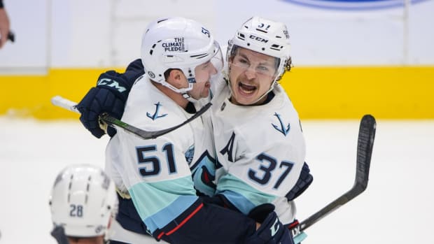 Apr 23, 2022; Dallas, Texas, USA; Seattle Kraken defenseman Derrick Pouliot (51) and center Yanni Gourde (37) celebrates a goal scored by Gourde against the Dallas Stars during the first period at the American Airlines Center. Mandatory Credit: Jerome Miron-USA TODAY Sports