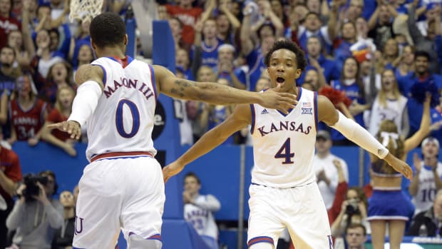 Feb 9, 2016; Lawrence, KS, USA; Kansas Jayhawks guard Devonte' Graham (4) celebrates with guard Frank Mason III (0) against the West Virginia Mountaineers in the second half at Allen Fieldhouse. The Jayhawks won 75-65. Mandatory Credit: John Rieger-USA TODAY Sports