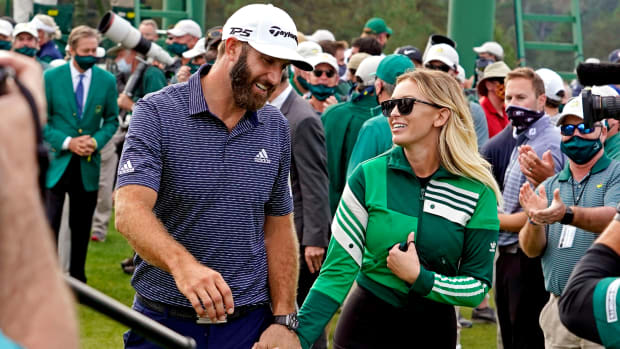 Dustin Johnson and Paulina Gretzky walk off the 18th green at Augusta National while holding hands.