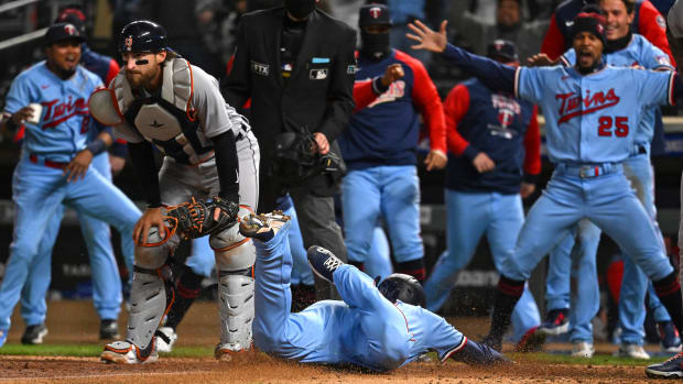 Minnesota Twins third base Gio Urshela (15) slides home for the game-winning run as teammates celebrate after a throwing error by Detroit Tigers catcher Eric Haase (13) during the ninth inning