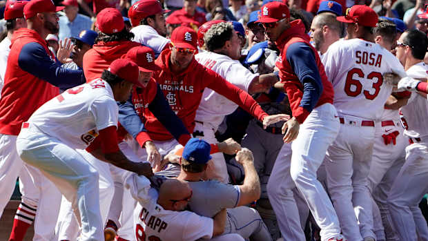 New York Mets’ Pete Alonso is taken to the ground by St. Louis Cardinals first base coach Stubby Clapp (82) and Alonso’s jersey is grabbed by Cardinals relief pitcher Genesis Cabrera, left, as benches clear during a scuffle in the eighth inning of a baseball game Wednesday, April 27, 2022, in St. Louis. Clapp was ejected from the game.